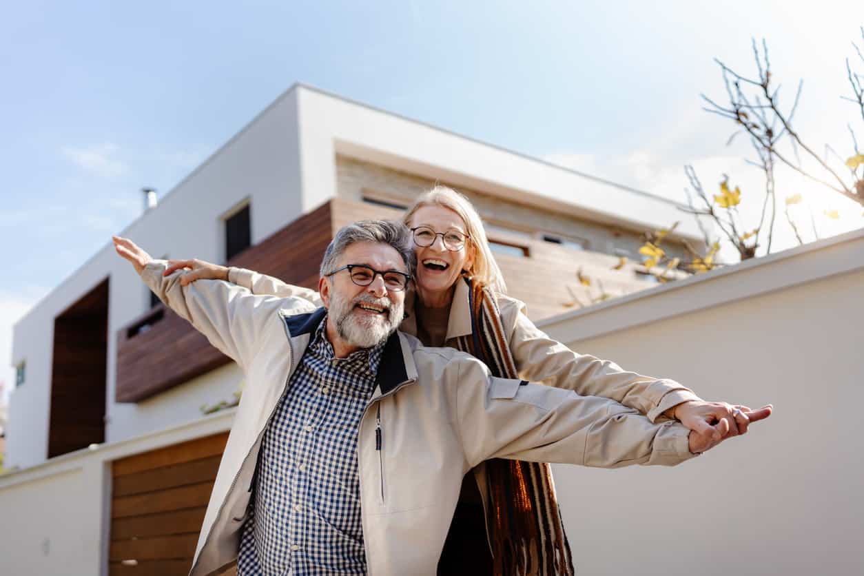 Älteres Paar vor modernem Haus — Vermögensvorsorge
